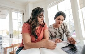 母亲与她的女儿检查学生作业