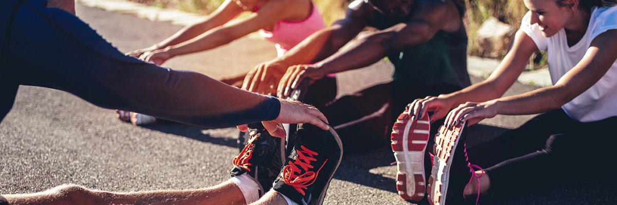 多民族的年轻成年运动员在跑步训练后做腿筋拉伸练习