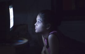 这是一张十几岁女孩看电视的照片