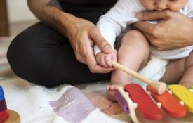 父亲教婴儿如何弹奏木琴