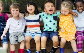 幼儿园的小朋友们朋友们挽着胳膊坐着笑着玩