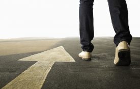 朝着箭头指向前方的方向行走的人