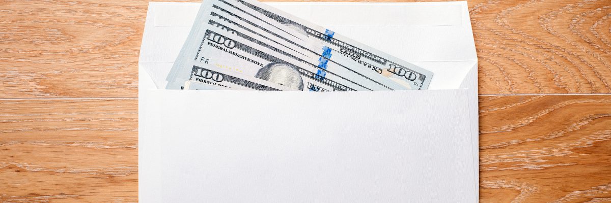 顶部视图空白信封与美元钞票在木制桌面。