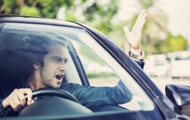 穿着体面的男司机愤怒地对着交通大喊大叫。