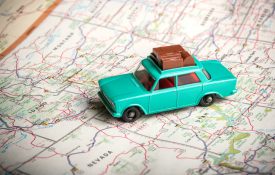 一辆老式玩具车，车顶上有行李，还有美国地图
