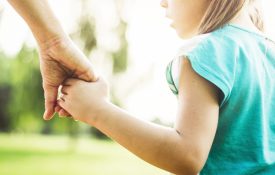 妈妈牵着女儿在公园里散步。