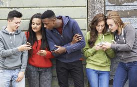 一群青少年在手机上分享短信