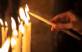 这是一张一个人点燃蜡烛的照片