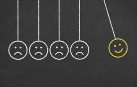 这是牛顿摇篮的插图，脸上有快乐和悲伤的表情