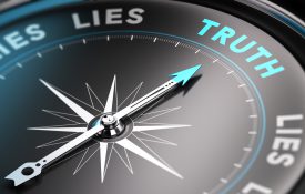 这是一张黑色指南针的照片，上面的针指向“真理”这个词。