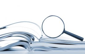 这是一张放大镜放在打开的书上的照片