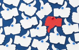 这是一张告示板上的一个红色拇指朝下，许多白色拇指朝上的插图