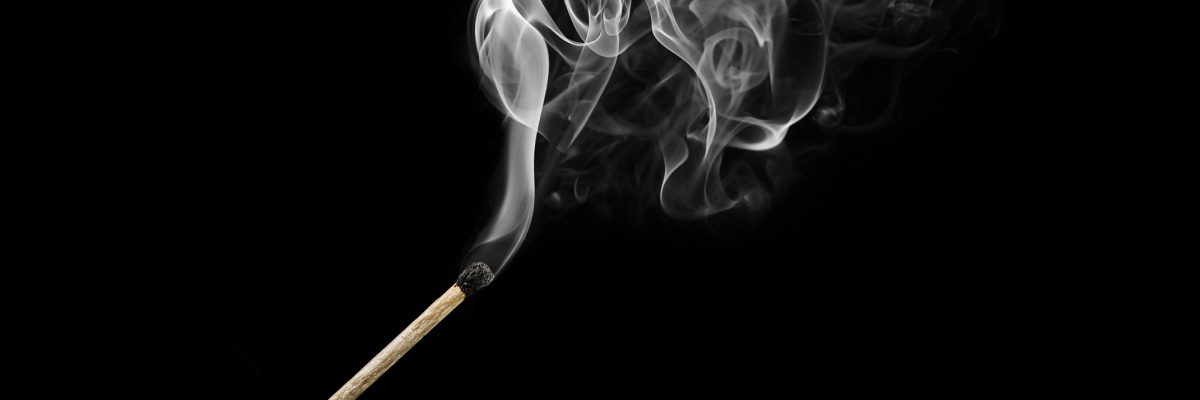 燃烧的火柴与烟卷隔离在黑色