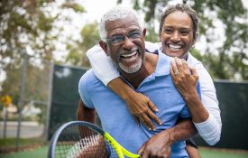 一对高年级的情侣在网球场上。