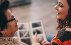 这是一张老女人和年轻女人一起看相册的照片